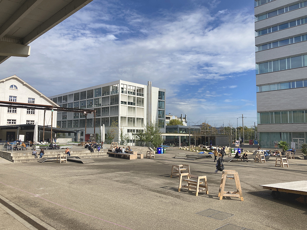 Central square of the campus area with renovated Freilager buildings and the new high-rise building.